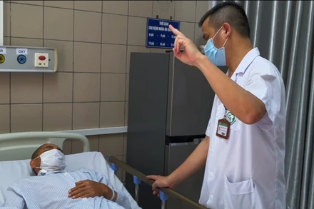 BS Nguyễn Trung Nguyên kiểm tra thị lực của bệnh nhân Covid-19.