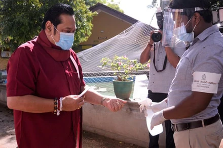 Thủ tướng Mahinda Rajapaksa sát khuẩn tay trước khi bỏ phiếu. (Ảnh: Tân Hoa xã)