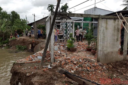 Một hộ dân đã tự di dời nhà sau khi bờ sông và sân nhà đã bị nước nhấn chìm xuống sông vào rạng 2-8.