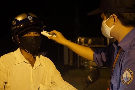 Đo thân nhiệt trước khi vào chợ.