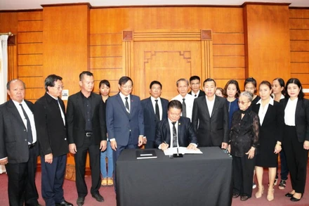 Chủ tịch Hội người Việt Nam Thủ đô Vientiane Lê Văn Mùi ghi sổ tang viếng nguyên Tổng Bí thư Lê Khả Phiêu, sáng 15-8.