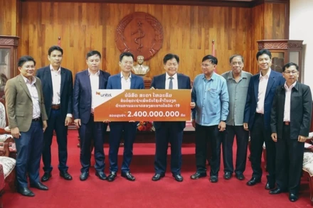 Bộ trưởng Y tế Lào Bounkong Sihavong (giữa) nhận tượng trưng 2,4 tỷ kíp Lào của Tổng Giám đốc Công ty Star Telecom Lưu Mạnh Hà.