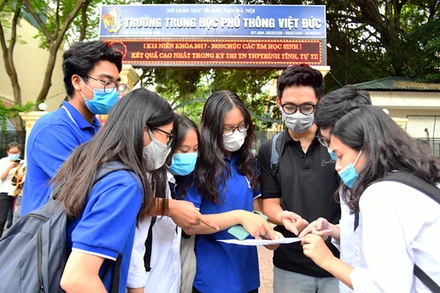 Thí sinh trao đổi bài sau buổi thi môn Ngoại ngữ tại điểm thi Trường THPT Việt Đức (quận Hoàn Kiếm, Hà Nội). Ảnh: MỸ HÀ