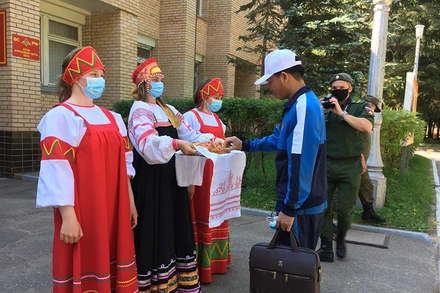 Thành viên Đội tuyển Huấn luyện chó nghiệp vụ được mời nếm bánh mỳ chấm muối, nghi thức tiếp đón truyền thống của phía bạn. Ảnh: NGỌC SÁNG