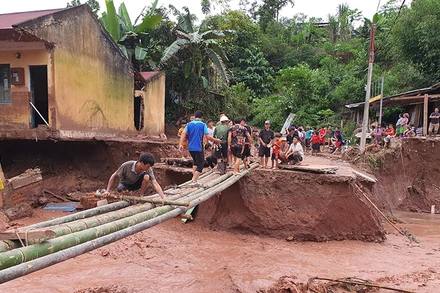 Lực lượng cứu hộ khẩn trương làm cầu tạm thay ngầm Nậm Nhừ 1 đã bị lũ cuốn trôi.