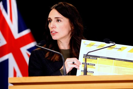 Thủ tướng New Zealand Ardern cầm bảng giới thiệu hệ thống cảnh báo Covid-19 mới tại Wellington, ngày 21-3. (Ảnh: AP)