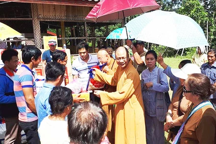Thượng tọa Thích Minh Quang tặng quần áo, đồ dùng cho người dân Lào.