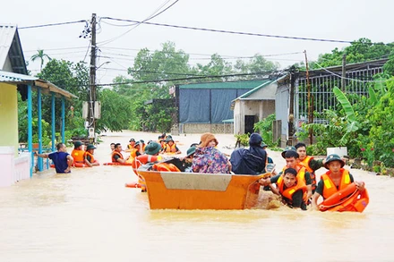 Cán bộ, chiến sĩ LLVT Quân khu 4 dầm mình trong mưa lũ để giúp đỡ nhân dân. Ảnh: TÂM QUANG