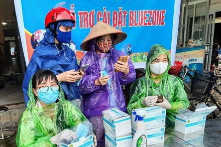 Hỗ trợ người dân cài ứng dụng Bluezone ở Hải Dương.
