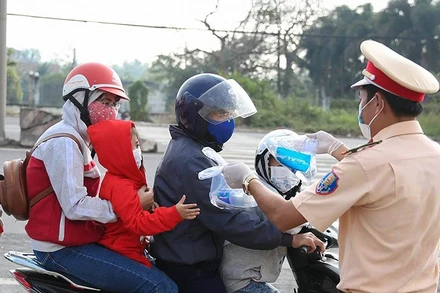 Lực lược CSGT phát khẩu trang, nước uống, khăn lạnh cho người dân trên quốc lộ 51.