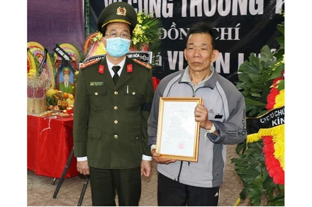 Thừa ủy quyền của Bộ trưởng Công an, lãnh đạo Cục Tổ chức - Cán bộ trao tới gia đình Quyết định thăng cấp bậc hàm trước niên hạn cho đồng chí Vi Văn Luân.