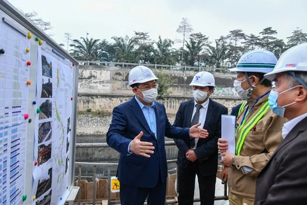 Đồng chí Vương Đình Huệ cùng các đồng chí lãnh đạo thành phố kiểm tra tại công trường xây dựng hệ thống cống bao cho sông Tô Lịch. (Ảnh: Duy Linh)