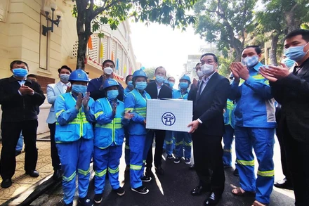 Chủ tịch UBND TP Chu Ngọc Anh tặng quà công nhân Tổ sản xuất số 7, chi nhánh Hoàn Kiếm của Công ty TNHH MTV Môi trường Đô thị Hà Nội.