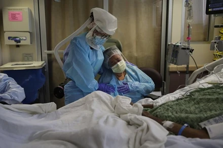 Bà Romelia Navarro ngồi bên giường bệnh của chồng là Antonio Navarro, khi ông đang hấp hối tại bệnh viện điều trị Covid-19 tại bang California, ngày 31-7-2020. (Ảnh: AP)