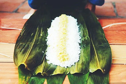 Gói bánh chưng bằng lá chít. Ảnh: SAOSTAR