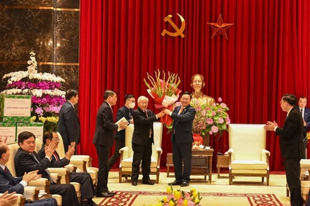 Bí thư Thành ủy Vương Đình Huệ tặng hoa chúc mừng Tổng Bí thư, Chủ tịch nước Nguyễn Phú Trọng. (Ảnh: DUY LINH)