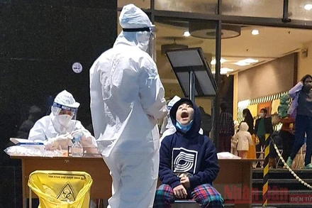 Cán bộ y tế lấy mẫu xét nghiệm cư dân chung cư 88 Láng Hạ (quận Đống Đa, Hà Nội).