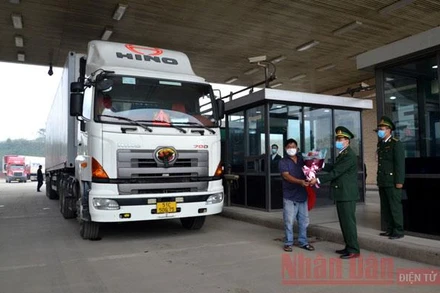 Biên phòng cửa khẩu Kim Thành tặng hoa cho lái xe chở chuyến thanh long đầu tiên xuất khẩu sang Trung Quốc.