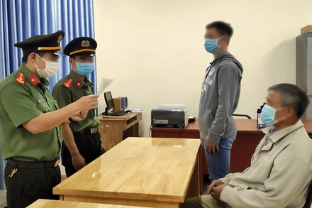 Cơ quan chức năng tống đạt quyết định xử phạt vi phạm hành chính đối với N.H.L (đứng, bên phải).