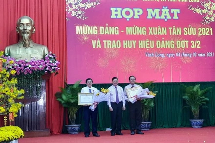 Bí thư Tỉnh ủy Vĩnh Long Trần Văn Rón thừa ủy quyền của Chủ tịch nước trao Huân chương Lao động hạng Nhì cho hai đồng chí ở Vĩnh Long.