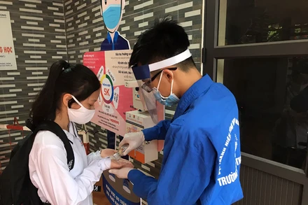 Các thí sinh được kiểm tra thân nhiệt và sát khuẩn tay trước khi vào phòng thi.