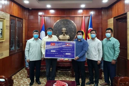 Đồng chí Bouahong Khamha (phải) trao 150 triệu kíp Lào để ủng hộ, đóng góp vào Quỹ vaccine phòng, chống Covid-19, ngày 12-6.