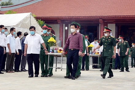 Đồng chí Nguyễn Chí Dũng, Bộ trưởng Kế hoạch và đầu tư và đồng chí Đặng Quốc Khánh, Bí thư Tỉnh ủy tỉnh Hà Giang tiễn đưa linh cữu các Anh hùng liệt sĩ về nơi yên nghỉ cuối cùng. (Ảnh: baohagiang.vn)