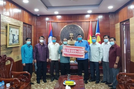 Bí thư, Tỉnh trưởng tỉnh Luang Prabang Khamkhan Chanthavisuk (trái) trao hỗ trợ cho Tổng Lãnh sự Nguyễn Đăng Hùng, ngày 8-6.