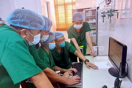 Các bác sĩ kiểm tra hệ thống theo dõi điều trị từ xa. (Ảnh: Trung Thành)