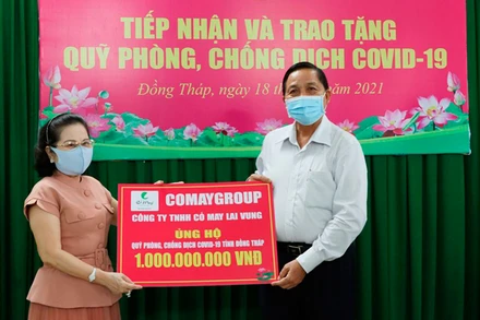 Đại diện doanh nghiệp trao tiền hỗ trợ Quỹ phòng, chống dịch Covid-19 tỉnh Đồng Tháp. (Ảnh: NGUYỆT ÁNH)