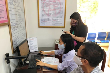 Cán bộ bộ phận một cửa phường Ngọc Lâm (quận Long Biên, Hà Nội) hướng dẫn công dân và nhập trên máy tính thực hiện dịch vụ công mức độ 3.