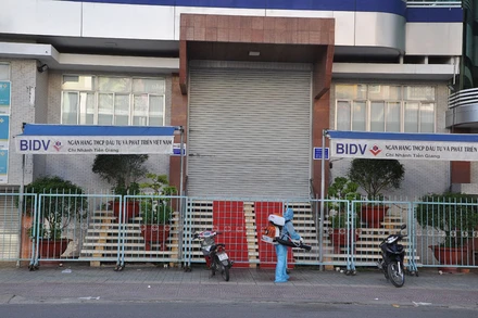 Lực lượng chức năng phun khử trùng tại Ngân hàng BIDV chi nhánh Tiền Giang sáng 27/6.