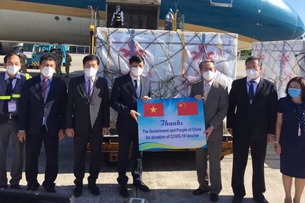 GS, TS Nguyễn Thanh Long - Bộ trưởng Y tế Việt Nam và ngài Hùng Ba - Đại sứ đặc mệnh toàn quyền nước CHND Trung Hoa trao biên bản bàn giao lô hàng viện trợ gồm 500.000 liều vaccine và hơn 500.000 bơm kim tiêm. (Ảnh: TRẦN MINH)