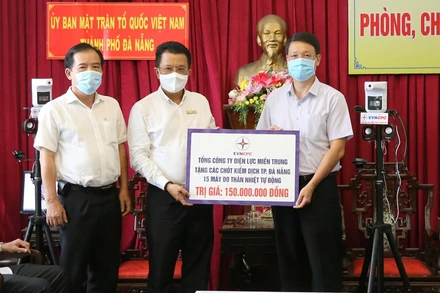 Tổng Giám đốc EVNCPC Ngô Tấn Cư (bên trái) trao bảng tượng trưng kinh phí hỗ trợ mua vaccine và 15 máy đo thân nhiệt tự động.