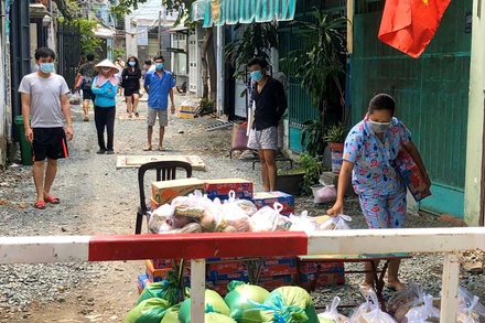 Người dân quận Gò Vấp trong khu cách ly nhận nhu yếu phẩm từ gian hàng 0 đồng, trong thời gian giãn cách xã hội.