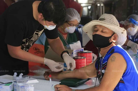 Nhân viên y tế lấy mẫu xét nghiệm cho một người dân ở thủ đô Bangkok. (Ảnh: Bưu điện Bangkok)
