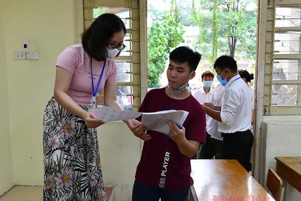 Cán bộ coi thi kiểm tra thông tin thí sinh tại Kỳ thi tốt nghiệp THPT 2020. ẢNh: THUỶ NGUYÊN