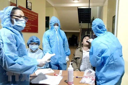 Lực lượng y tế của Trung tâm y tế huyện Vân Đồn triển khai lấy mẫu xét nghiệm cho người dân trên địa bàn. (Ảnh: TTXVN)