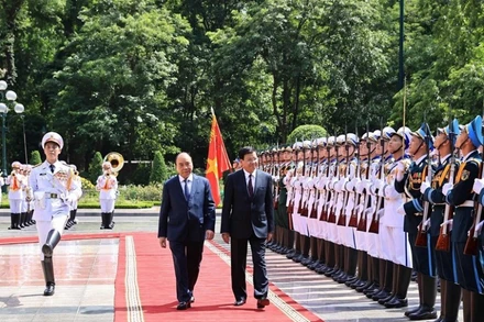 Chủ tịch nước Nguyễn Xuân Phúc và Tổng Bí thư Ban Chấp hành Trung ương Đảng Nhân dân Cách mạng Lào, Chủ tịch nước Cộng hòa Dân chủ Nhân dân Lào Thongloun Sisoulith duyệt Đội danh dự Quân dội nhân dân Việt Nam. (Ảnh: TTXVN)
