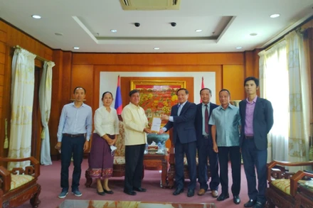 Phó Chủ tịch Quốc hội Lào Khambay Damlath (thứ ba từ trái sang) trao hỗ trợ tại trụ sở Đại sứ quán Việt Nam tại Lào.