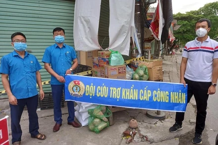 Anh Bùi Văn Trường (áo trắng) nhận hỗ trợ từ Đội cứu trợ khẩn cấp công nhân.