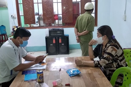 Lực lượng chức năng lập biên bản đối với chủ quán Huyền Cát Tuyền (nữ, bìa phải), tối 2-6.