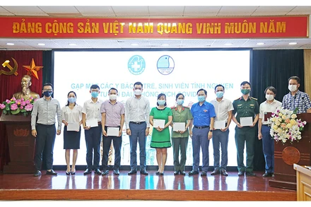 Các đồng chí Nguyễn Anh Tuấn (thứ năm, từ phải qua trong ảnh) và Hà Anh Đức (thứ năm, từ trái qua trong ảnh) trao các suất quà tặng một số y, bác sĩ trẻ, sinh viên tình nguyện ngành y tiêu biểu trên tuyến đầu chống dịch.