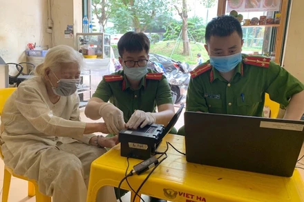 Các đồng chí trong tổ cấp CCCD, Công an quận Ba Đình, thực hiện lấy dấu vân tay tại nhà cho cụ Phạm Thị Mỹ.