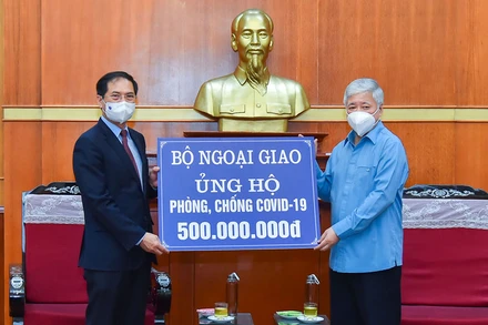 Bộ trưởng Ngoại giao Bùi Thanh Sơn trao tượng trưng số tiền 500 triệu đồng tới Bí thư Trung ương Đảng, Chủ tịch Ủy ban Trung ương Mặt trận Tổ quốc Việt Nam Đỗ Văn Chiến. (Ảnh: MOFA)