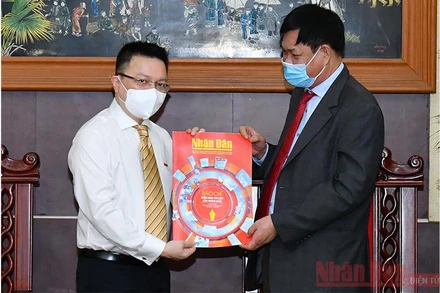 Đồng chí Lê Quốc Minh tặng đồng chí Huỳnh Tấn Việt (bên phải) số báo đặc biệt nhân ngày 21-6. (ẢNH: THỦY NGUYÊN)