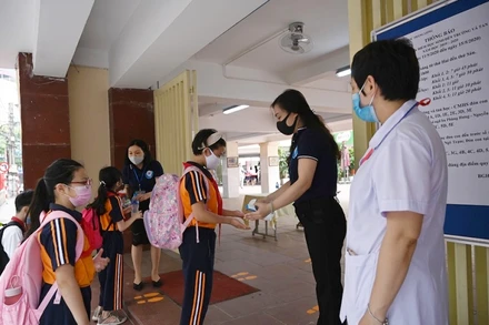 Học sinh Trường tiểu học Thăng Long (Hoàn Kiếm, Hà Nội) rửa tay sát khuẩn, kiểm tra thân nhiệt trước khi vào trường học trực tiếp. (Ảnh: Duy Linh)