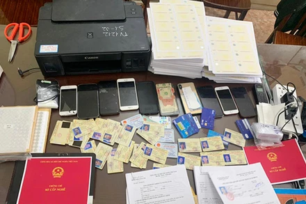 Một phần tang vật vụ án triệt phá ổ nhóm chuyên sản xuất các loại giấy phép lái xe giả tại Hà Nội. Ảnh: Báo Công an nhân dân