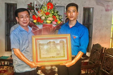 Chủ tịch UBND tỉnh Nam Định Phạm Đình Nghị trao cho anh Nguyễn Đức Chính Bằng khen của Thủ tướng Chính phủ vì hành động dũng cảm cứu người.