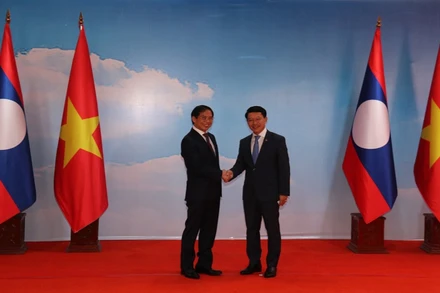 Bộ trưởng Ngoại giao Lào Saleumxay Kommasith (phải) tiếp đón Bộ trưởng Ngoại giao Việt Nam Bùi Thanh Sơn.